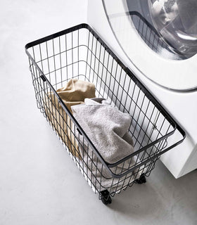 View of Rolling Wire Basket by Yamazaki Home in black from above with several towels inside. view 13