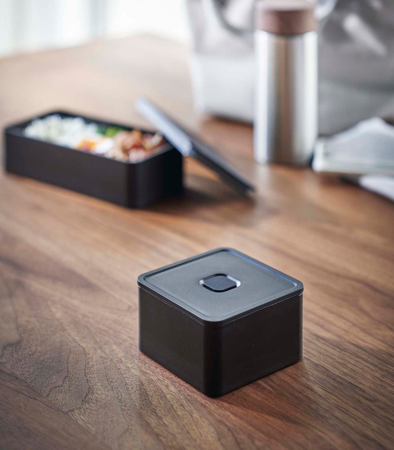 Black Vacuum-Sealing Bento Box on table by Yamazaki Home.