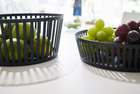 Close up front view of black Fruit Basket holding grapes and fruit on white tabletop by Yamazaki Home. view 7