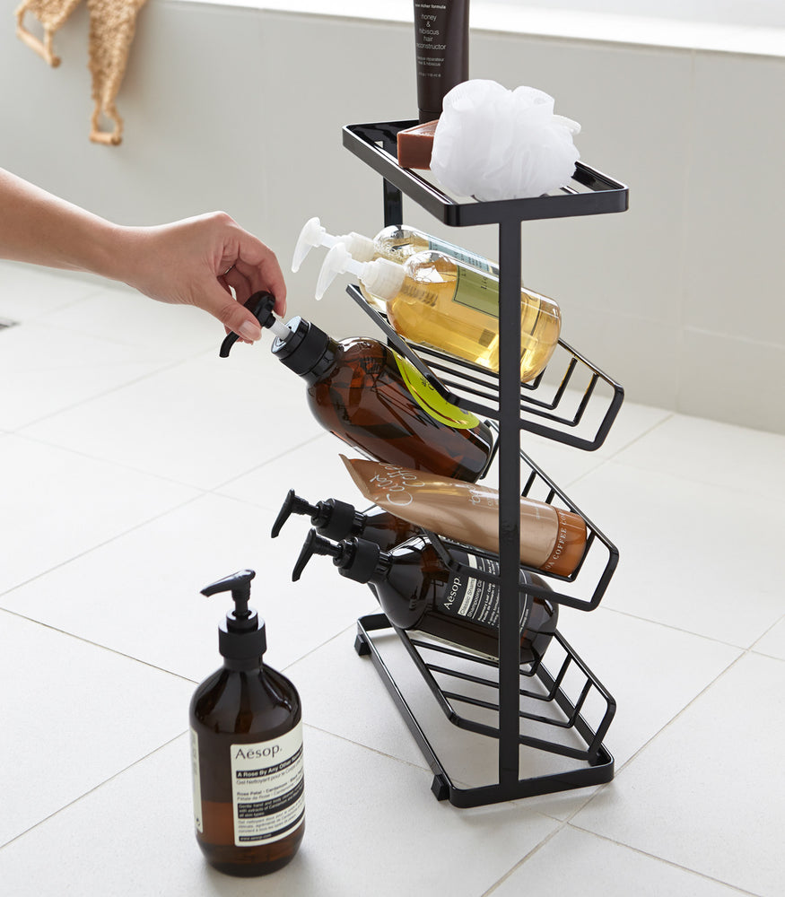 View 14 - Side view of black Freestanding Shower Caddy holding beauty products by Yamazaki Home.