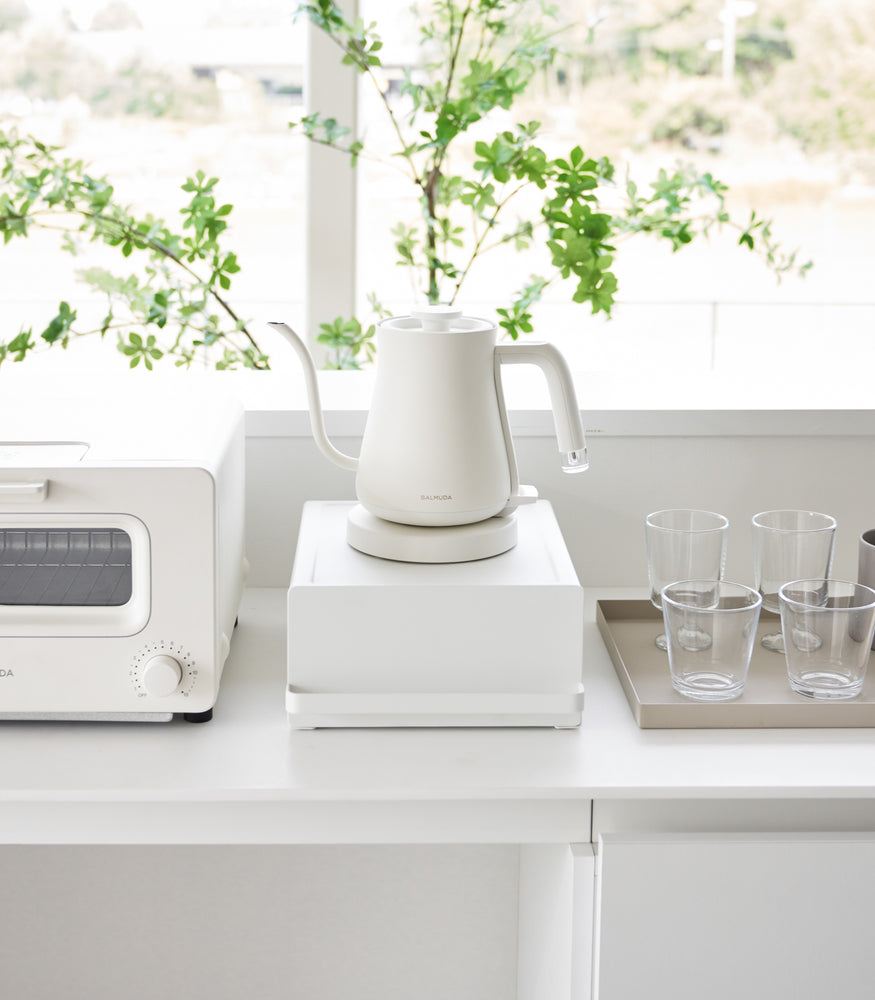 View 7 - Front view of Yamazaki Home White Countertop Rack with Drawer with a kettle.