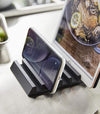 Close up view of black Phone and Tablet Stand holding phone and tablet on counter by Yamazaki Home.