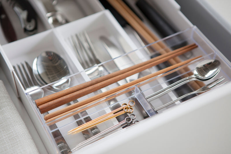 Close up aerial view of white Expandable Drawer Organizer holding utensils by Yamazaki Home.