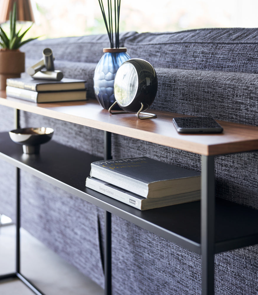 View 29 - Close up of black Yamazaki Home Long Console Table - Shelf  with books and decorations on it