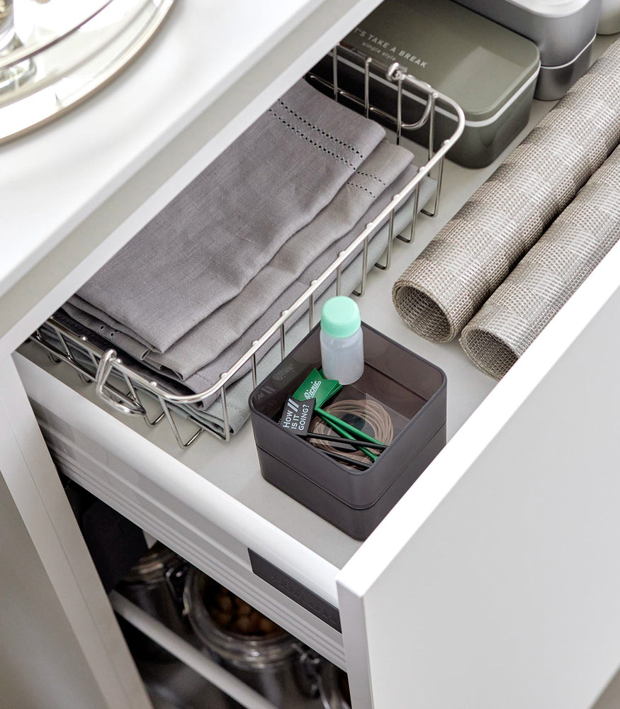 View 11 - Two small stackable clear organizers in black are placed in a kitchen drawer, one on top of the other, showcasing how they can be neatly stacked.