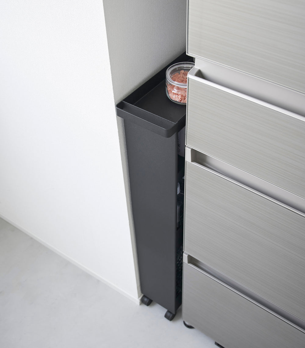 Black Yamazaki Home Slim Rolling Cart in a tight corner of a kitchen