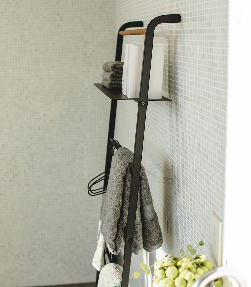 View 23 - Side view of black Leaning Ladder Rack with Shelf holding towels in bathroom by Yamazaki Home.