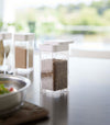 White Yamazaki Home Spice Jar opened with the slotted side on a table