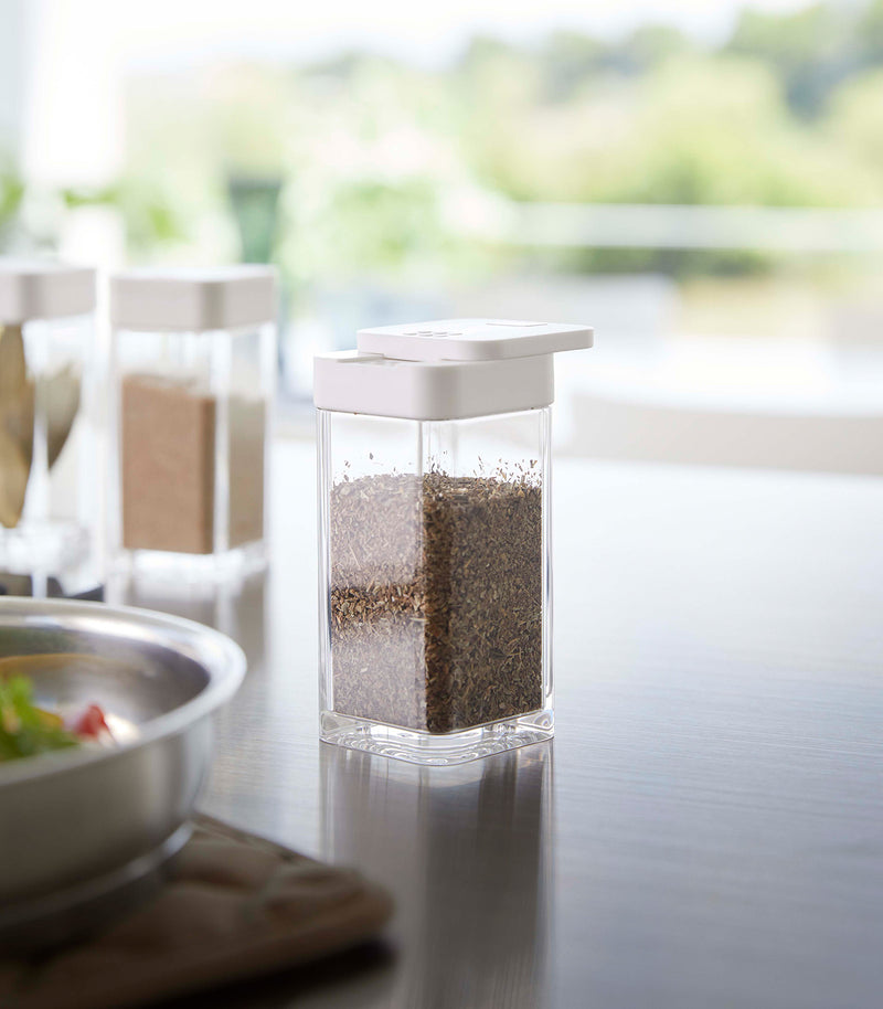 White Yamazaki Home Spice Jar opened with the slotted side on a table