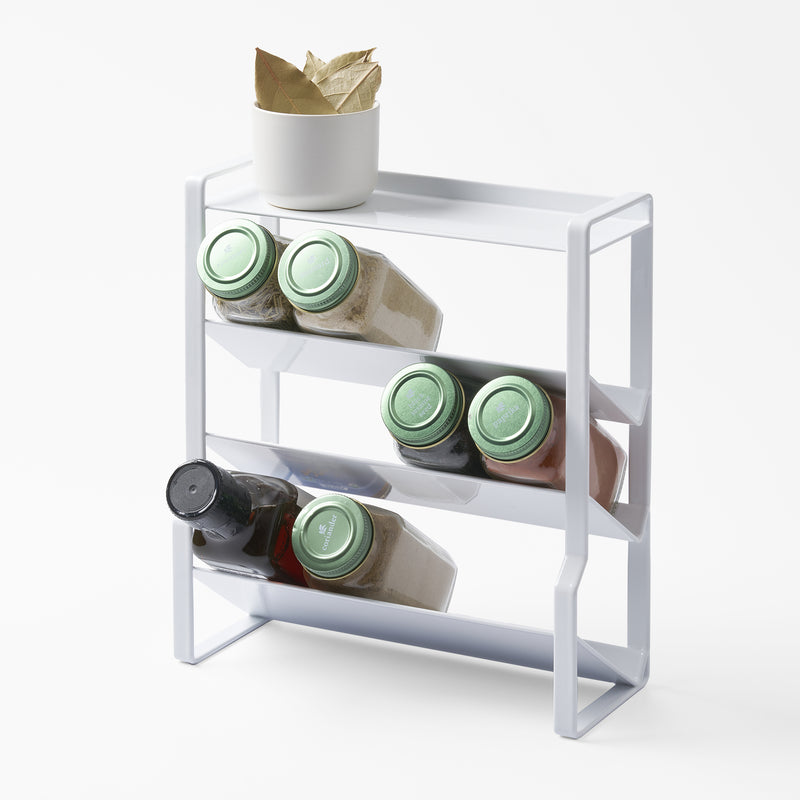 Yamazaki Home White Four-Tier Slim Spice Rack with props, set against a white background.