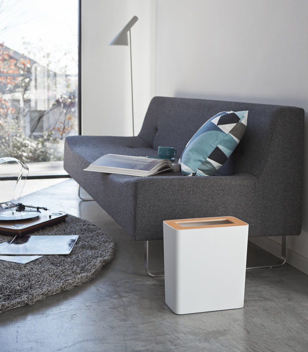 Side view of white Trash Can in living room by Yamazaki Home.
