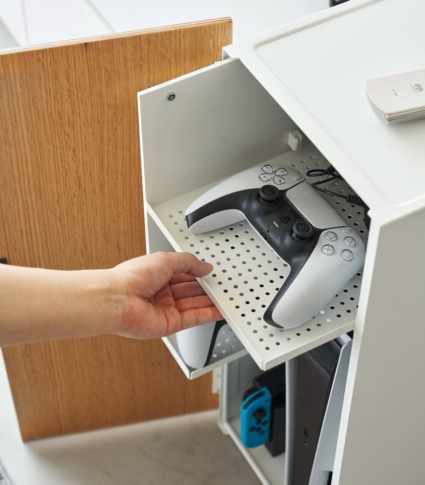 View 4 - A game controller is neatly placed on the top sliding shelf, which features a grid of holes.