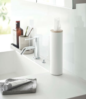 Small white Yamazaki Home Round Tissue Case on a sink counter view 3