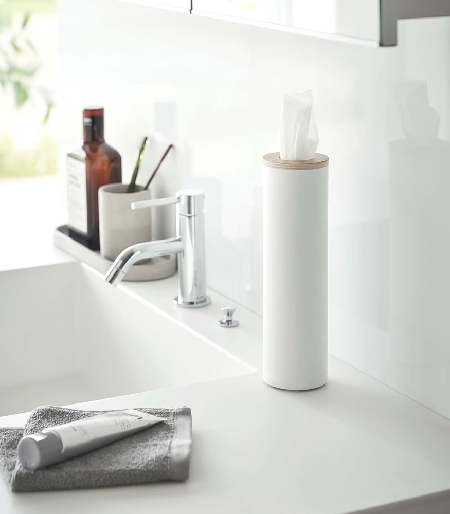 View 3 - Small white Yamazaki Home Round Tissue Case on a sink counter