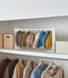 White Yamazaki Home hat rack hanging a variety of hats in a closet