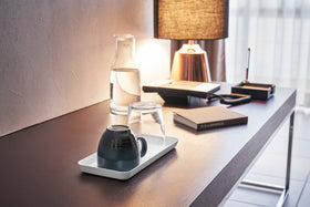 White Accessory Tray holding mug and glass on desk by Yamazaki Home. view 16