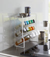 White Four-Tier Slim Spice Rack by Yamazaki Home in a well-lit kitchen, equipped with a variety of spices and essentials.