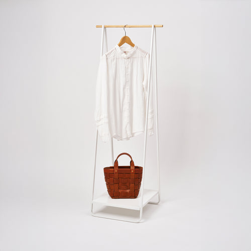 Yamazaki Home Coat Rack with Shelf with props, set against a white background.