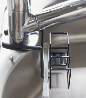 Side view of black Steel Yamazaki Home Faucet-Hanging Sponge & Brush Holder holding a brush view 16