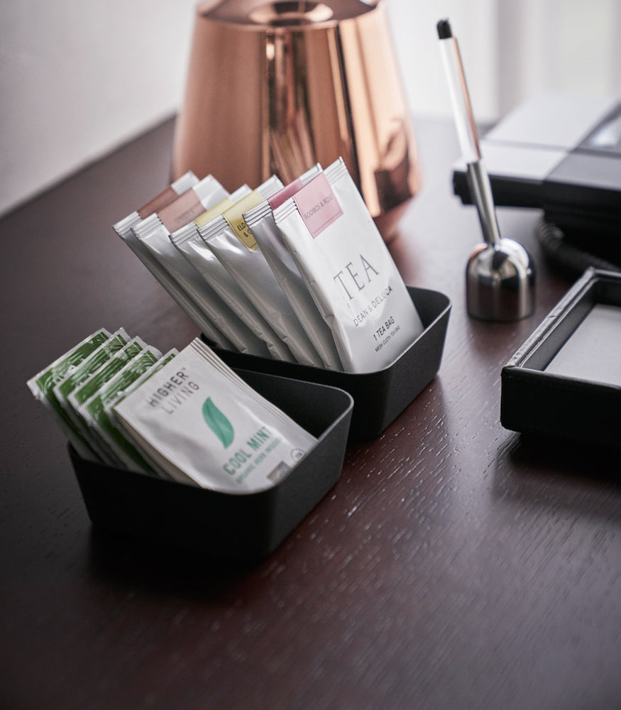 View 10 - Side view of small black Accessory Trays holding tea bags on office table by Yamazaki Home.