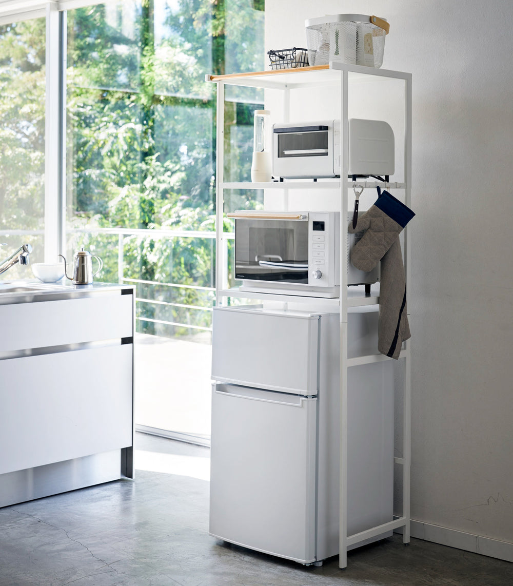 White Storage rack holding kitchen equipment in kitchen by Yamazaki Home.