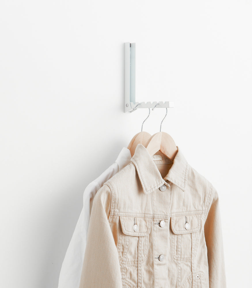 View 4 - White Over-the-Door Hanger holding jackets on wall by Yamazaki Home.