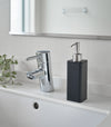 Black Hand Soap Dispenser on bathroom counter by Yamazaki Home.