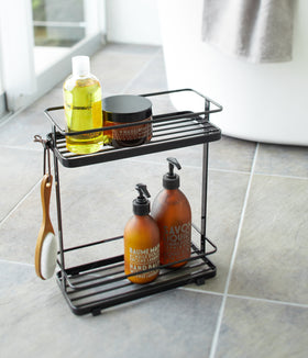 Black Shower Caddy holding shower items in bathroom by Yamazaki Home. view 6