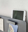 Closeup of a phone resting on top of a Yamazaki black Magnetic Wall Panel