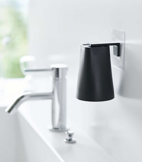 Black Yamazaki Home traceless adhesive magnetic cup installed next to sink view 6