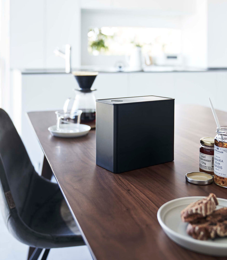 View 16 - Black Yamazaki Home kitchen storage box with a closed lid on dining table