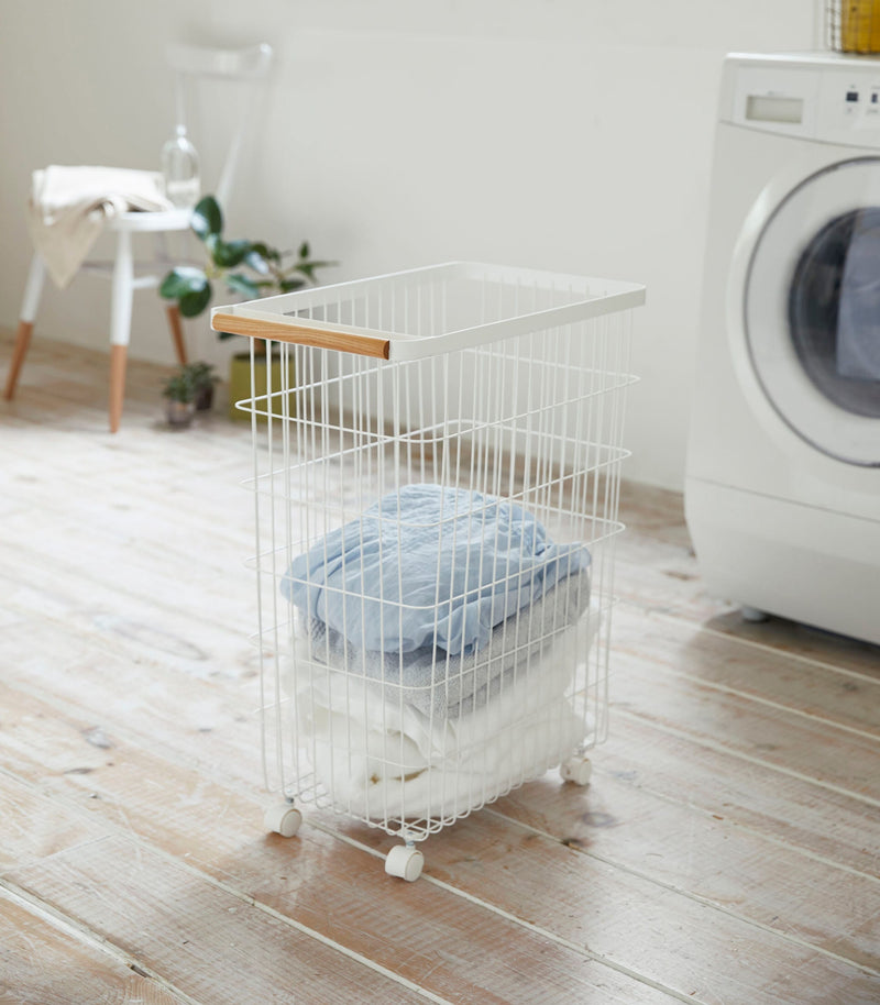 Rolling Wire Basket holding clothes by Yamazaki Home.