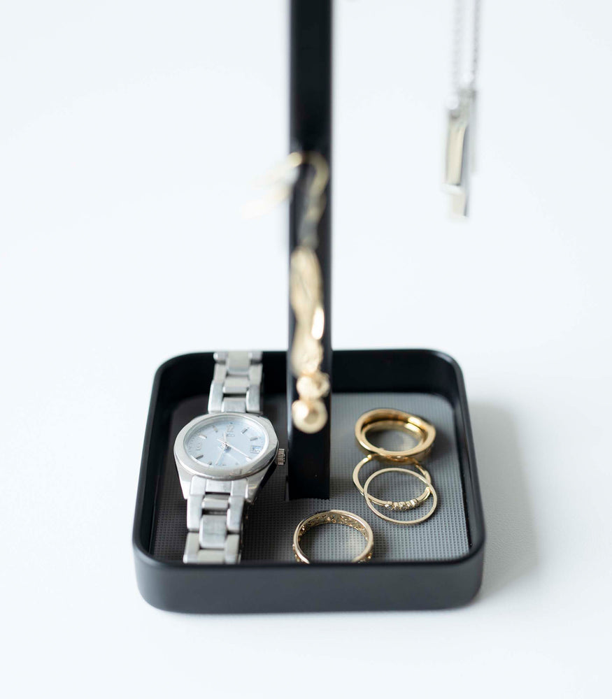 View 11 - Close up of black Yamazaki Home Tree Accessory Stand containing rings and a watch