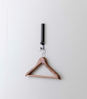 Black Yamazaki Home Folding Over-The-Door Hanger mounted closed with hangers hung view 26