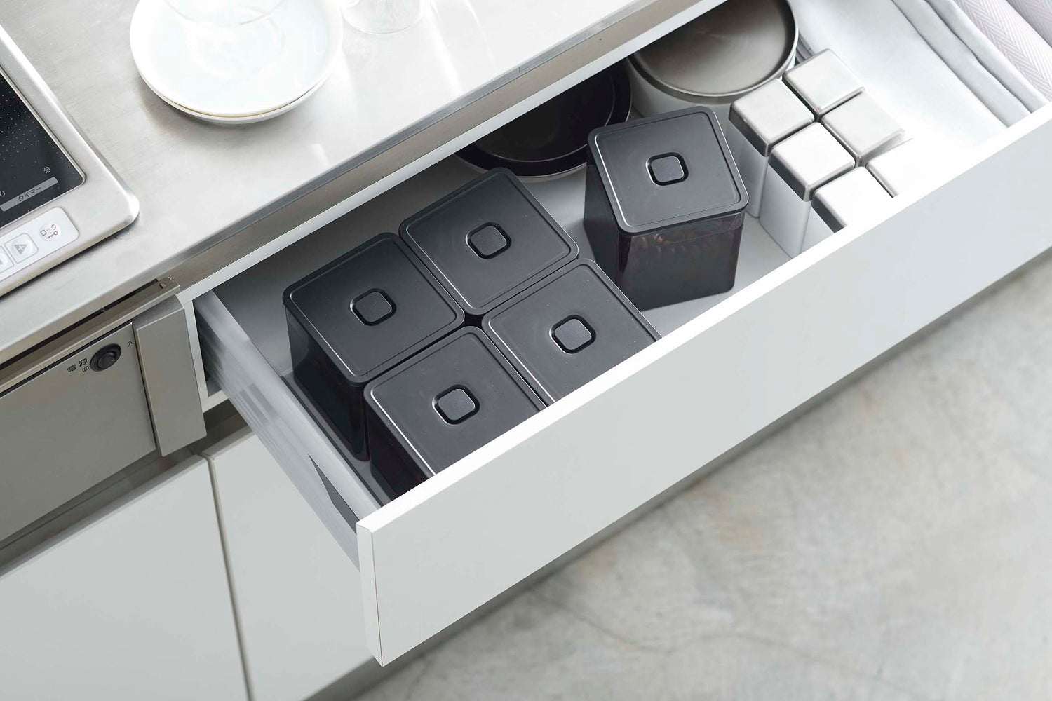 View 27 - Aerial view of black Vacuum-Sealing Food Containers w. Spoon in kitchen drawer by Yamazaki Home.