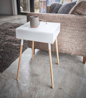 Side view of white Storage Table holding cup and glasses in living room by Yamazaki Home. view 9