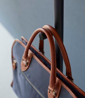 Close up of black Yamazaki Coat Rack arm with a messenger bag on it view 15