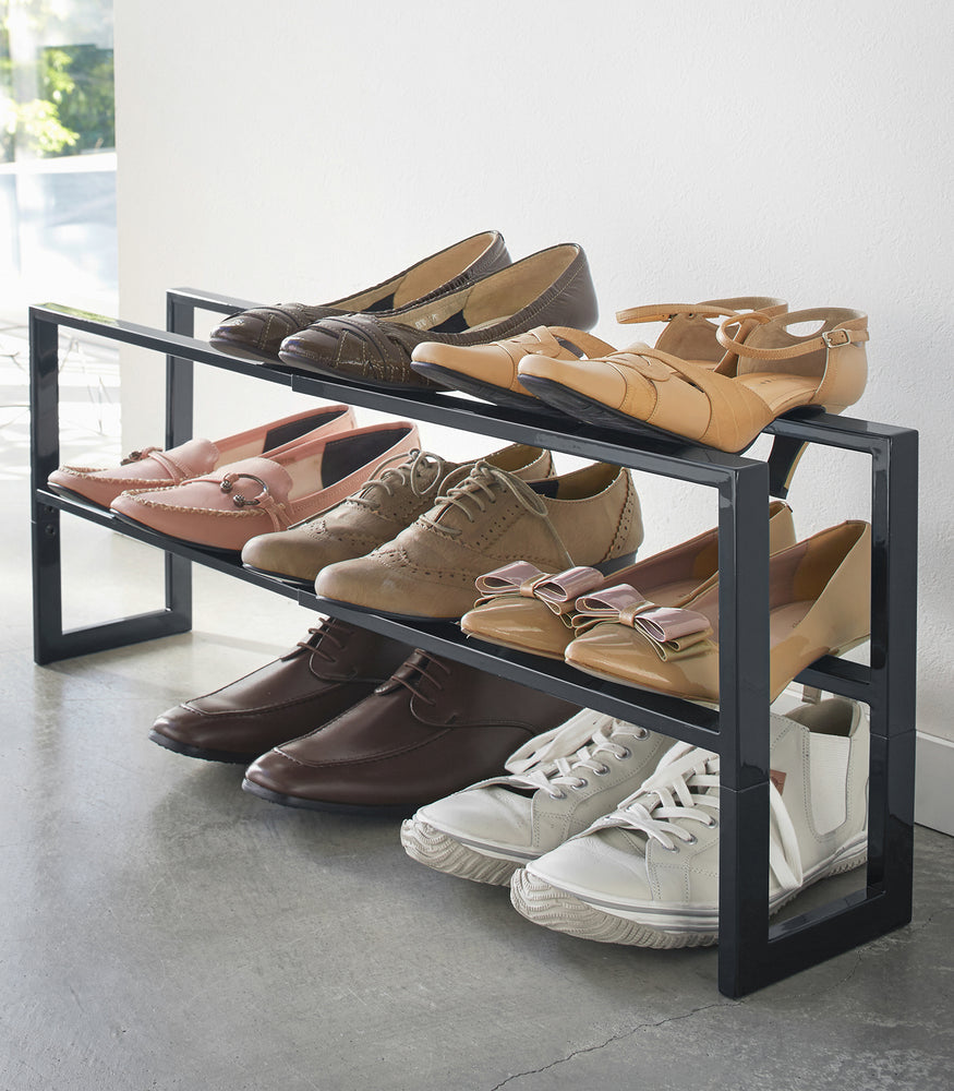 View 19 - Black entryway Expandable Shoe rack holding shoes by Yamazaki Home.