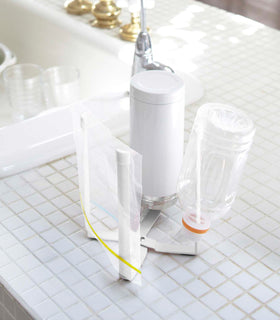 Small white Yamazaki Collapsible Bottle Dryer on a kitchen counter drying a bag and bottles view 4