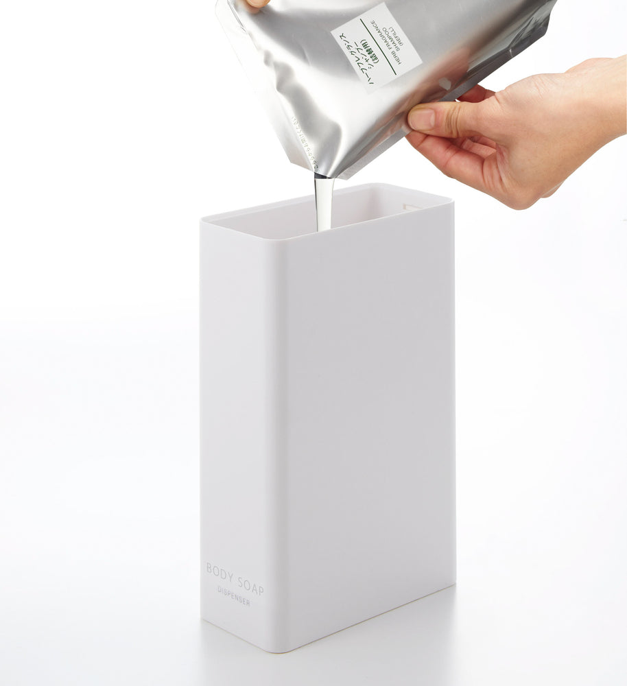 View 24 - White Body Soap Dispenser filled with soap on white background by Yamazaki Home.