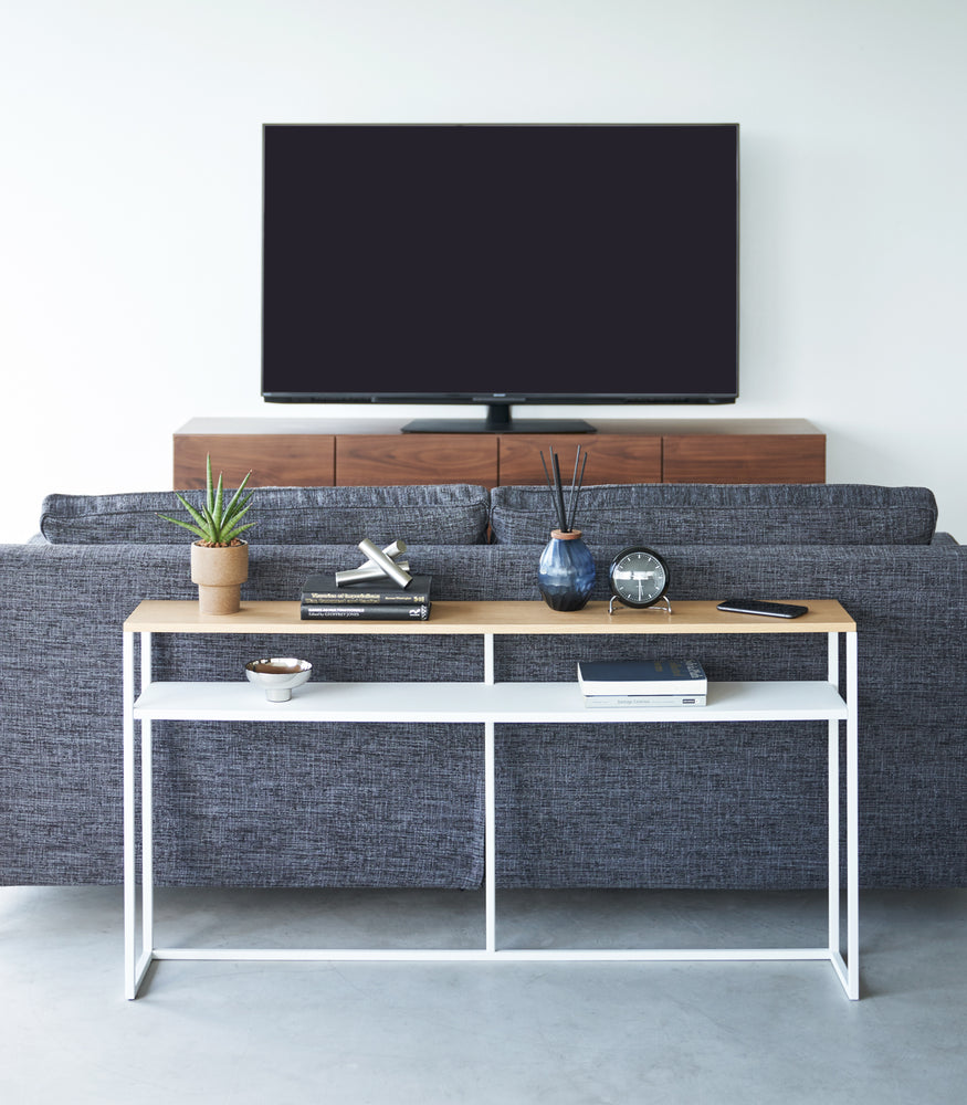 View 20 - Frontal image of white Yamazaki Home Long Console Table - Shelf with books and decorations on it