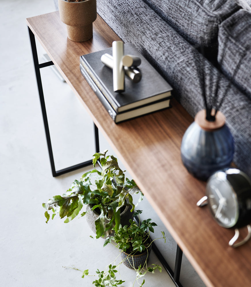 View 13 - An image of the Long Console Table in black by Yamazaki Home from above, set by the back of a couch.