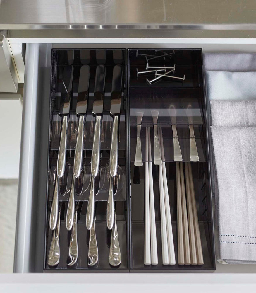View 11 - Aerial view of two black Cutlery Storage Organizers holding utensils in kitchen drawer by Yamazaki Home.