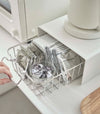 White Yamazaki Home Stackable Countertop Shelf with a basket filled with coffee supplies underneath being removed