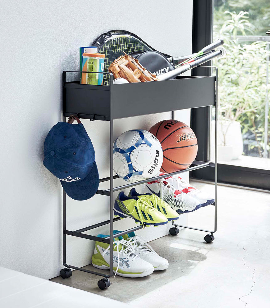 View 11 - Black Yamazaki Entryway Organizer with shoes and sports equipment on it