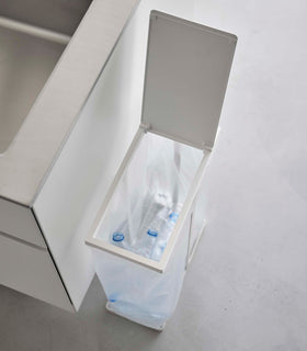 White Yamazaki Home Lidded Garbage Bag Holder holding plastic bottles view 3