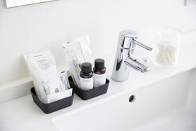 Black Accessory Tray holding beauty products on sink counter in bathroom by Yamazaki Home. view 8