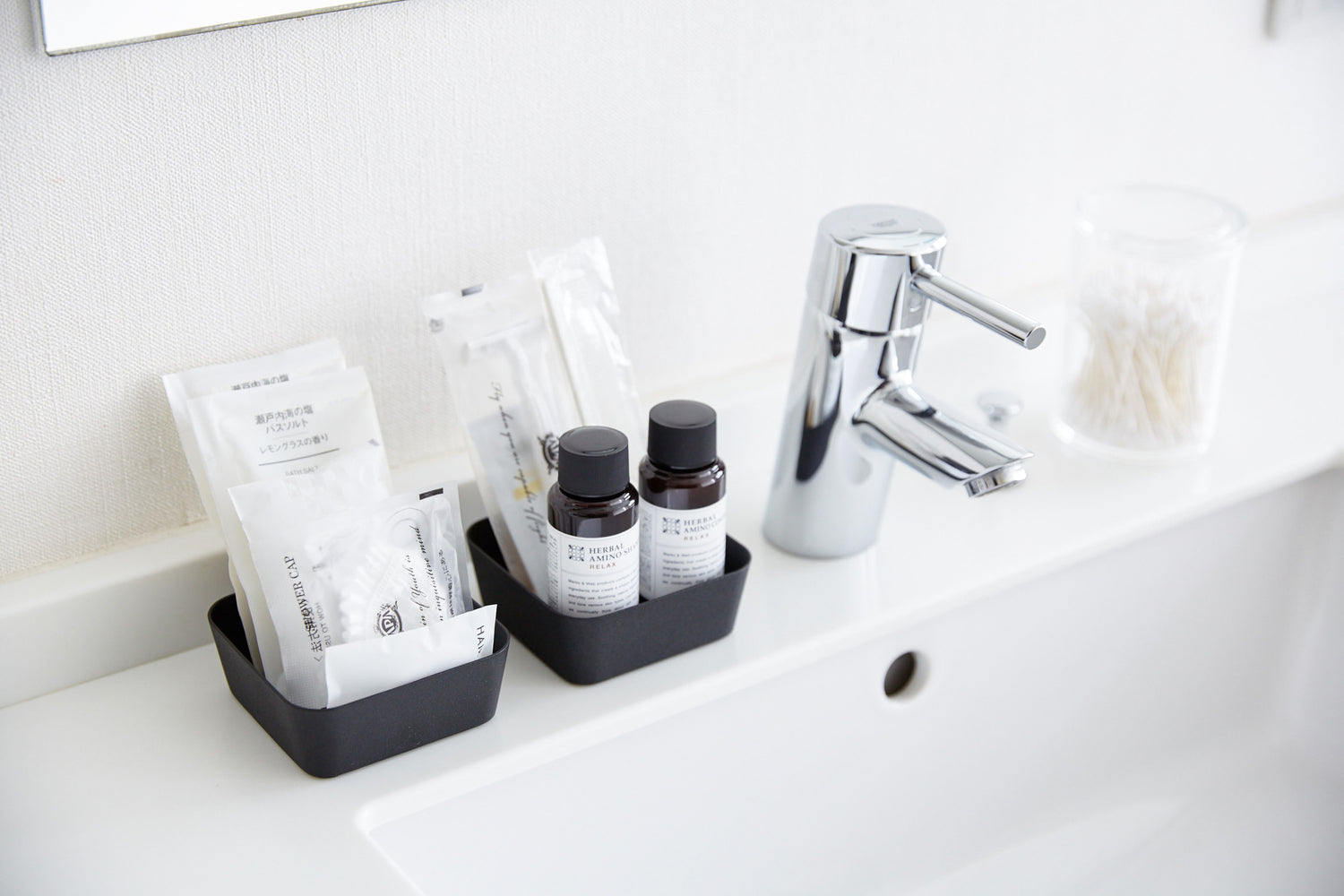View 8 - Black Accessory Tray holding beauty products on sink counter in bathroom by Yamazaki Home.