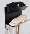 Close-up of the shelves on the Magnetic Entryway Rack by Yamazaki Home in black. Various entryway items are stored on the rack including gloves and a dog leash.
