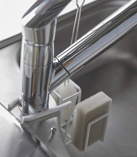 Rear of white Steel Yamazaki Home Faucet-Hanging Sponge & Brush Holder attached to a faucet view 7